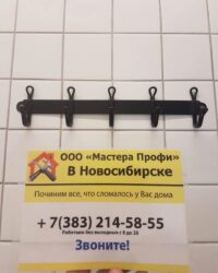 Настенная вешалка с пятью крючками на фоне белой плитки. Внизу - рекламная листовка компании "Мастера Профи".