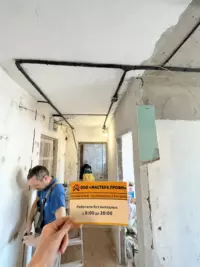 Процесс замены электропроводки: мастер в защитных перчатках монтирует силовой кабель
