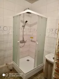 Установка угловой душевой кабины с матовыми стеклами в ванной комнате