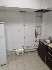 Готовая кухня в офисном помещении с раковиной, подключенной через санитарный насос-измельчитель